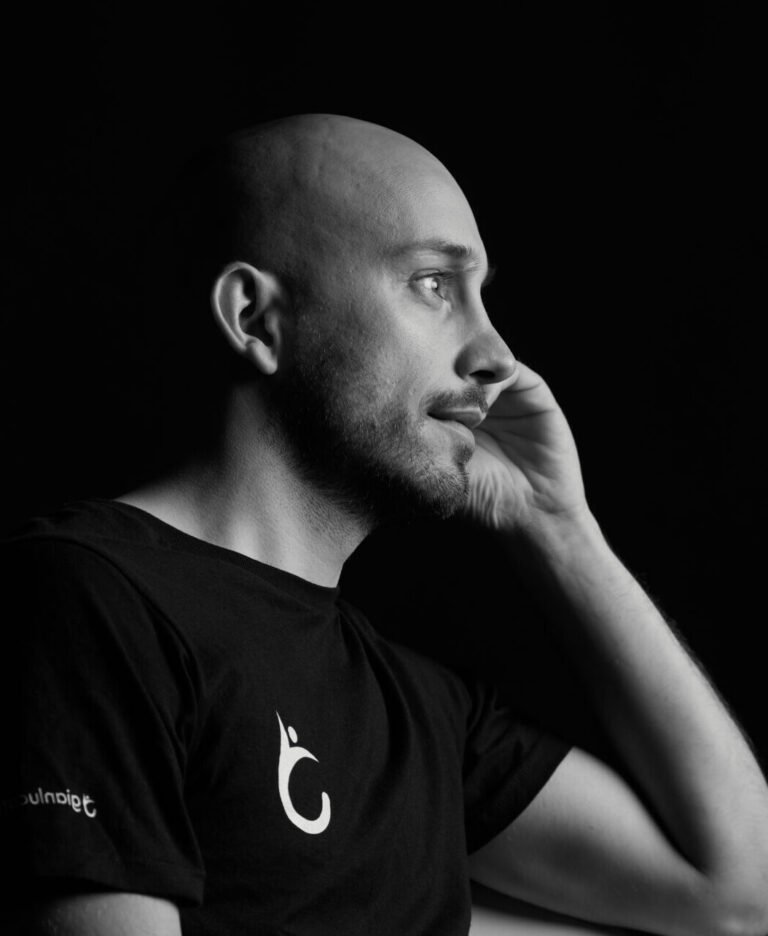 gianluca tomasi che guarda a destra in bianco e nero con sguardo dolce stya riflettendo su il suo metodo dualment